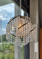 A glorious modern, round sparkling crystal chandelier sets the mood, a ceiling lamp for every home